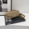 Elegante marsupio kaki con strass in pelle poggiato su un libro decorativo nero - Marrone
