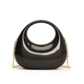 Detail of black acrylic crescent handbag with gold chain strap and glossy round handle - Black