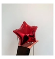 Macro shot of bright red star-shaped acrylic evening bag with glossy metallic finish - Red