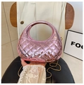 Detail einer pinkfarbenen gesteppten Handtasche mit Bogengriff und Goldkette - Rosa