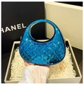 Macro detail of glossy blue acrylic clutch bag with quilted pattern inside a gift box - Blue
