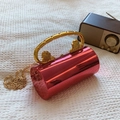 Red cylinder clutch bag with golden lion head handles and chain strap on white mesh - Rose Red