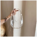 Detailed view of egg-shaped clear acrylic evening bag with gold chain and metal clasp - Clear