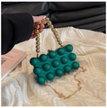 Detail of green acrylic bubble texture clutch with gold round handle and chain strap - Green