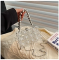 Close-up of transparent acrylic clutch bag with bubble texture and silver beaded handle - Clear