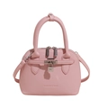 Detailopname van roze schelptas met litchi-korreltextuur en metalen hangslot accent - Roze