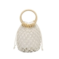 Detail of macrame cotton rope beach bag with wooden handle and woven mesh texture - White
