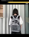 Vue arrière d'un sac à dos transparent en PVC avec bordure grise porté en ville - Sac Unique / Gris