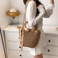 Detail der Strohtasche mit großer champagnerfarbener Seidenschleife und Schultergurt - Khaki