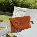 Detail van de handgeweven oranje stro-enveloppe clutch voor strandvakanties - Oranje