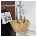 Detail of a natural straw woven tote bag featuring premium brown leather shoulder straps - Apricot