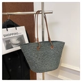 Detail of dark green woven tote bag with brown leather straps on a hanger - Dark Green