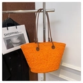 Detail of a large orange woven tote bag with brown leather straps for beach vacations - Orange