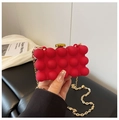 Detail of red acrylic bubble clutch bag featuring gold chain and metallic twist lock - Red