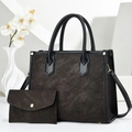Detail of dark brown tote bag with suede texture and matching small pouch on white stand - Coffee
