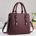 Elegant wine red handbag with textured finish, featuring top handles and silver hardware - Red