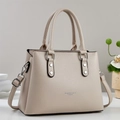 Close-up of beige lychee texture handbag with silver lettering and metal strap buckle - Khaki