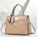 Detail of khaki leather handbag with pleated texture, gold lock, and patterned silk scarf - Khaki