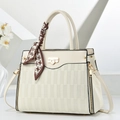 Close-up of cream textured faux leather bag with elegant houndstooth scarf handle detail - White