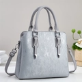 Détail d'un sac à main gris clair en cuir synthétique texturé avec finitions argentées - Gris