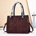 Detail of burgundy tote bag showing leather texture and decorative printed silk scarf - Wine Red