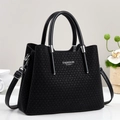 Nahaufnahme der schwarzen Tasche mit Flechtstruktur und silbernem FASHION Queen Logo - Schwarz