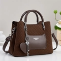 Vue détaillée du sac cabas marron avec texture tressée et breloques cœur - café