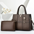 Détail du sac cabas marron foncé à motif crocodile avec logo V doré et breloques en métal - café