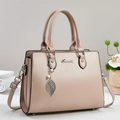 Elegant beige faux leather tote bag with top handles and pearl leaf charm in soft lighting - Khaki