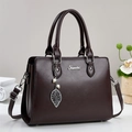 Detail of dark brown leather tote with silver Fematoz logo and leaf pearl pendant - Coffee