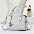 Silver snakeskin tote bag with top handles, gold heart pendant, and adjustable shoulder strap - Silver