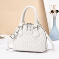 White quilted shell handbag with silver hardware and adjustable shoulder strap - White