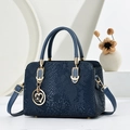 Navy blue snake embossed crossbody handbag with gold hardware and floral charm pendant - Blue