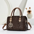 Detail of dark brown snakeskin embossed texture with heart charm and gold hardware - Brown