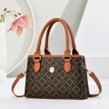 Elegante bruine handtas met monogram en gouden gesp op een minimalistische achtergrond - Donkerbruin Klaverpatroon