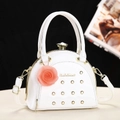 White semi-circular patent leather handbag with gold rivets and pink floral charm - White