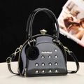 Elegante borsa in pelle verniciata nera con borchie dorate e ciondolo a fiore 3D - Nero