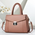 Dusty pink faux leather tote bag with silver T-lock and adjustable strap on white pedestal - Pink