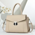 Detailed side view of beige pebble grain leather handbag with silver T-lock and orchid - Light Khaki