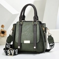 Deep green textured leather handbag with brown handles and a wide contrast woven strap - Green