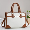 Retro minimalist white handbag with brown leather trim and silver clasp in a bright setting - White