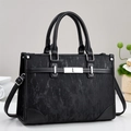 Detail of black structured tote bag with brushed texture and silver hardware accents - Black