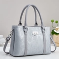 Gray textured shoulder bag with metallic finish and silver twist-lock on grey background - Gray