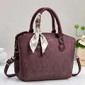 Close-up of burgundy retro handbag with ribbed texture and striped silk scarf detail - Red