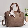 Détail du sac à main vintage marron texturé avec foulard et bandoulière en cuir - café