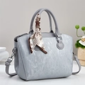 Détail d'un sac à main bleu clair en cuir texturé avec un foulard en soie décoratif chic - Gris