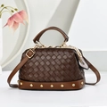 Bolso de mano marrón de cuero trenzado con marco retro y tachuelas doradas sobre fondo blanco - Marrón