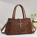 Retro dark brown crossbody handbag with top handles and adjustable strap on a minimalist stand - Brown
