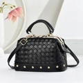 Detalle del bolso de cuero trenzado negro con tachuelas doradas y acabados metálicos - Negro