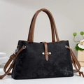 Detail of classic black and brown handbag featuring silver rivets and leather texture - Black
